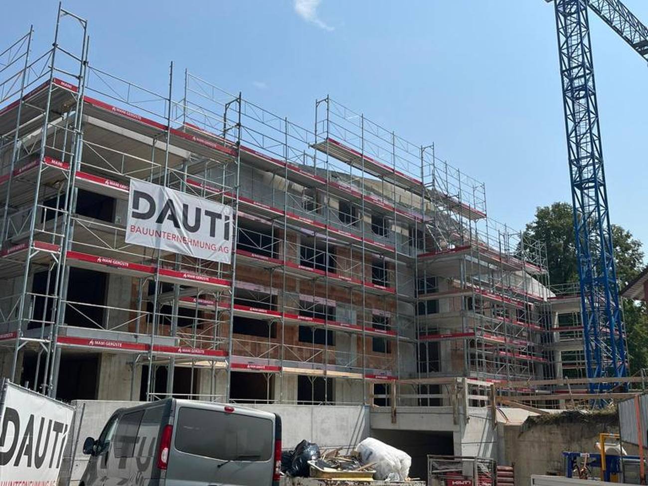 Baustelle mit Gerüst und Fahrzeugen der DAUTI Bauunternehmung AG